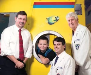 Drs. William Ferguson, Saar Danon and Charles Huddleston with Cardinal Glennon kid Alec Ingram