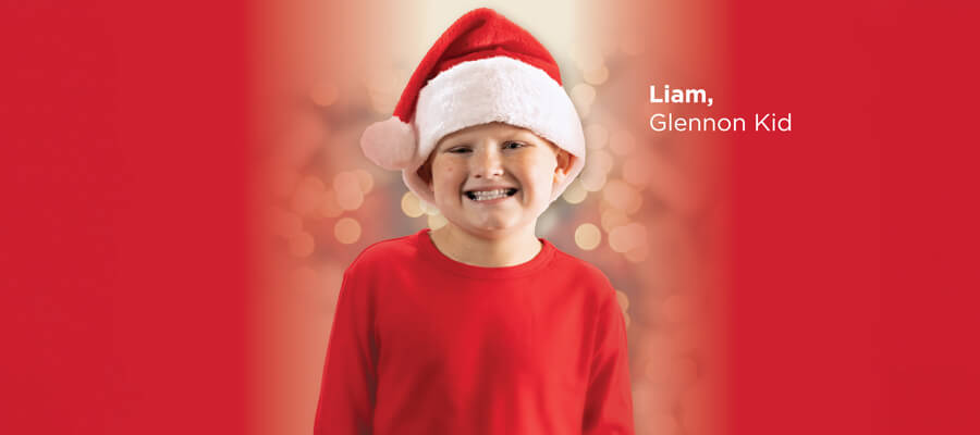 Cardinal Glennon kid, Liam - red background wearing Santa hat
