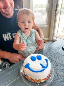 Chase - at home in dad's lap with a smile-face cake