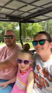 Kenzie - sitting on mom's lap, riding in a golf cart with dad driving