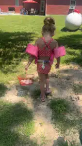 Kenzie - at home collecting chicken eggs in swimsuit