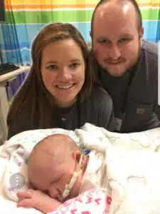 Kenzie - sleeping in hospital bed with mom and dad in background