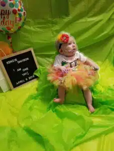 Kenzie - one year portrait with sign board in background