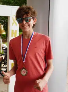 Logan - posing with "Last Chemo Bell" outside Cardinal Glennon