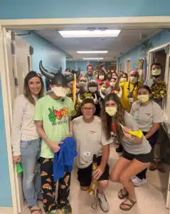Logan - celebration photo with family and large care team posing in in-patient cancer unit