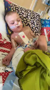 Easton - in PICU bed with heart bandage on chest