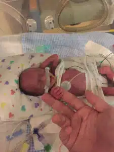 Colten - neonatal newborn holding dad's finger in isolette