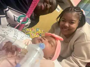 Jadai - floor time with mom and dad in background of NICU room