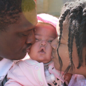 Jadai - close-up with mom and dad kissing her cheeks