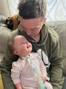 Josie in dad's lap smiling up at him