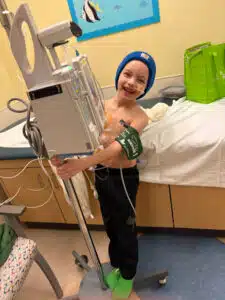 Wyatt smiling while riding on his IV pole in The Costas Center