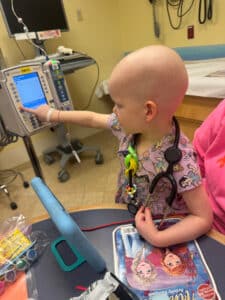 Cardinal Glennon patient Bristol pressing a button on her pump inside the Costas Center