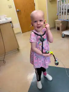 Cardinal Glennon patient Bristol listening to a stethoscope inside the Costas Center