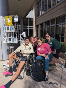 Quincy in a wheelchair outside Cardinal Glennon with his care team