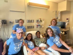Quincy in hospital bed surrounded by people wearing "Transplant Warrior" t-shirts