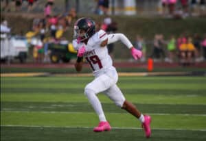 a high school football player running on the field