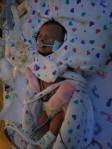 photo of a newborn baby in a NICU bed at night
