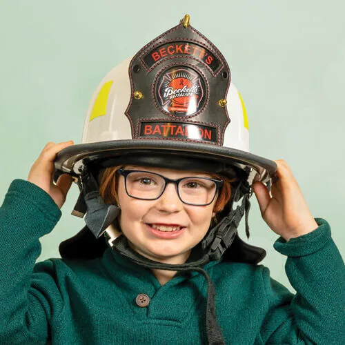 Beckett wearing his fireman hat in a green sweater