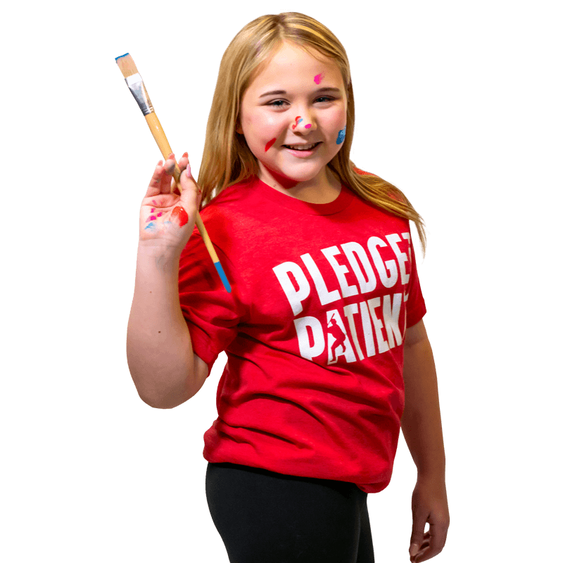 Cardinal Glennon kid, Libby holding a paint brush wearing a "Pledge for Patients" t-shirt