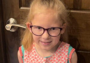 Kenzie - smiling at home in front of door